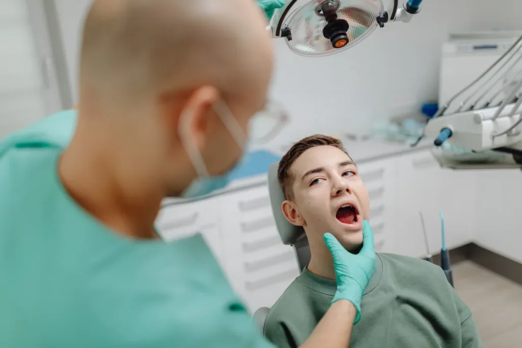 Dentist examining young patient mouth before wisdom teeth removal consultation in Pasadena